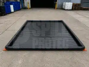Batea robusta integral SpillProtec en planta industrial para contención de derrames industriales