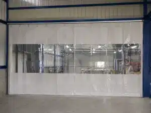 Cortina industrial corrediza con ventana de cristal diviendo un deposito