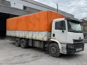 Lona para proteccion de cargas de camion en color naranja puesta en camion